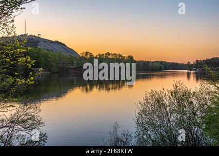 Blick auf den Sonnenuntergang auf das Atlanta Evergreen Lakeside Resort und den Stone Mountain Park Campground Jurten am Seeufer im Stone Mountain Park in Atlanta, Georgia. Stockfoto