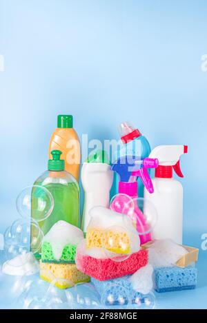 Spring Home Reinigung, Housekeeping-Konzept, Satz von verschiedenen hellen Reinigungsartikeln, Flaschen, Utensilien, Lieferungen. Auf hellblauem Hintergrund mit Seifenblasen Stockfoto