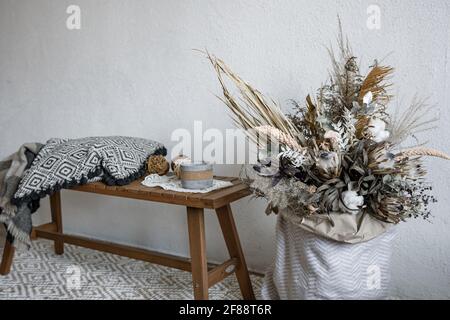 Gemütliches Interieur-Design im skandinavischen Stil mit dekorativen Elementen und einer trendigen Komposition aus getrockneten Blumen. Stockfoto