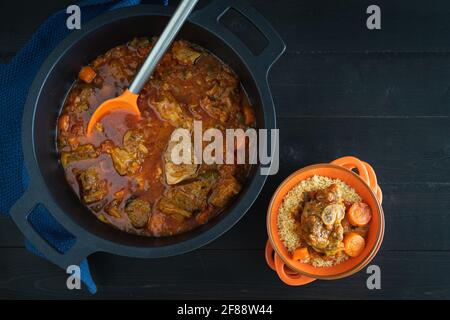Lammeintopf mit Gemüse und Couscous auf schwarzem Hintergrund. Ramadan-Konzept. Speicherplatz kopieren. Stockfoto