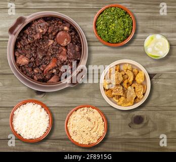 Typisch brasilianische Feijoada mit Caipirinha und Beilagen über Holz Tabelle Stockfoto