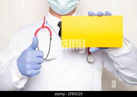 Nahaufnahme eines männlichen Arztes, der eine positive Geste macht Halten Sie ein Zeichen mit Leerzeichen für Text Stockfoto