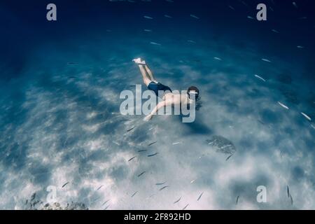 Männlicher Freitaucher gleitet ohne Flossen unter Wasser im blauen Meer Stockfoto