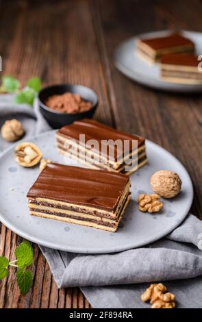 Köstlicher Kakao- und Walnusskuchen mit Pflaumenmarmelade, gekrönt mit Schokoladenfrosting Stockfoto