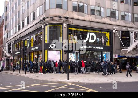 Eine große Gruppe von Einkäufern wartet vor dem Eingang auf die Eröffnung des JD Sports Stores in der Oxford Street, da die nicht unbedingt notwendigen Geschäfte nach der 4. Sperre wieder geöffnet werden. Stockfoto