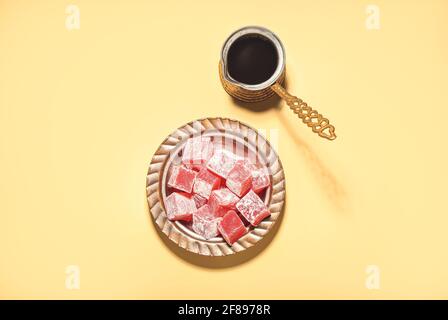 Türkische Delight und Kaffeekocher auf farbigem Hintergrund Stockfoto