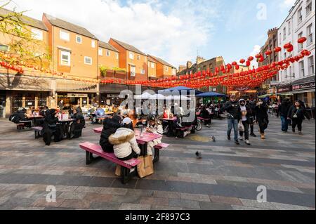 London, Großbritannien. 12. April 2021. Menschen, die in Chinatown Speisen und Getränke genießen, wo Restaurants nach der Coronavirus-Roadmap der britischen Regierung, die heute nicht unbedingt erforderliche Unternehmen wiedereröffnen konnte, im Freien speisen. Kredit: Stephen Chung / Alamy Live Nachrichten Stockfoto