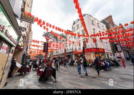 London, Großbritannien. 12. April 2021. Menschen, die in Chinatown Speisen und Getränke genießen, wo Restaurants nach der Coronavirus-Roadmap der britischen Regierung, die heute nicht unbedingt erforderliche Unternehmen wiedereröffnen konnte, im Freien speisen. Kredit: Stephen Chung / Alamy Live Nachrichten Stockfoto