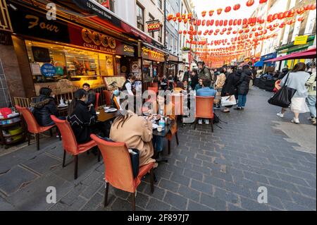 London, Großbritannien. 12. April 2021. Menschen, die in Chinatown Speisen und Getränke genießen, wo Restaurants nach der Coronavirus-Roadmap der britischen Regierung, die heute nicht unbedingt erforderliche Unternehmen wiedereröffnen konnte, im Freien speisen. Kredit: Stephen Chung / Alamy Live Nachrichten Stockfoto