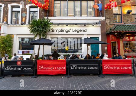 London, Großbritannien. 12. April 2021. Menschen, die in Chinatown Speisen und Getränke genießen, wo Restaurants nach der Coronavirus-Roadmap der britischen Regierung, die heute nicht unbedingt erforderliche Unternehmen wiedereröffnen konnte, im Freien speisen. Kredit: Stephen Chung / Alamy Live Nachrichten Stockfoto