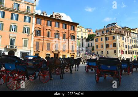 Pferdekutschen auf der Piazza di Spagna mit Blick auf die Spanische Treppe im Hintergrund in Rom, Italien. Stockfoto