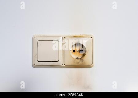 Nahaufnahme eines Elektrobrands mit dem Kabel und dem Wandstecker Stockfoto