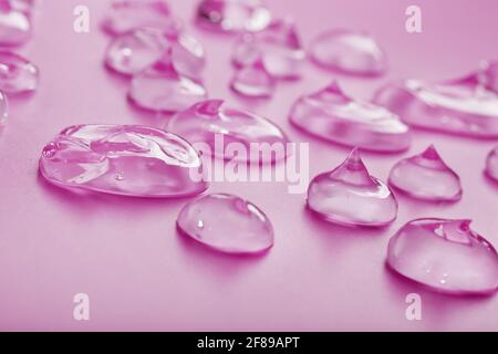 Transparentes flüssiges Gel auf einem rosa Hintergrund mit freiem Platz. Antiseptisches, kosmetisches Gel Stockfoto