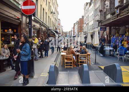 London, Großbritannien. April 2021. Belebte Bars und Restaurants in der Old Compton Street, Soho. Geschäfte, Restaurants, Bars und andere Unternehmen haben heute nach fast vier Monaten wieder geöffnet, da sich die weiteren Sperrregeln in England lockern. Stockfoto