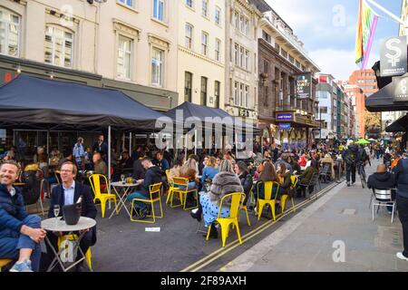 London, Großbritannien. April 2021. Belebte Bars und Restaurants in der Old Compton Street, Soho. Geschäfte, Restaurants, Bars und andere Unternehmen haben heute nach fast vier Monaten wieder geöffnet, da sich die weiteren Sperrregeln in England lockern. Stockfoto