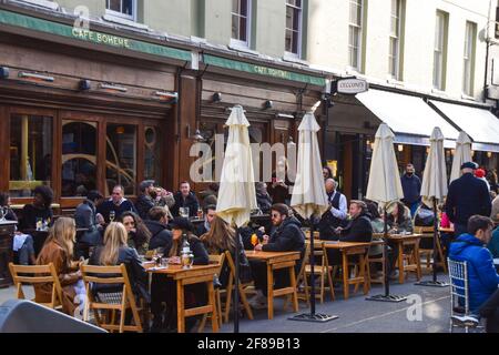 London, Großbritannien. April 2021. Belebte Bars und Restaurants in der Old Compton Street, Soho. Geschäfte, Restaurants, Bars und andere Unternehmen haben heute nach fast vier Monaten wieder geöffnet, da sich die weiteren Sperrregeln in England lockern. Stockfoto