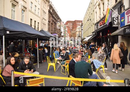 London, Großbritannien. April 2021. Belebte Bars und Restaurants in der Old Compton Street, Soho. Geschäfte, Restaurants, Bars und andere Unternehmen haben heute nach fast vier Monaten wieder geöffnet, da sich die weiteren Sperrregeln in England lockern. Stockfoto