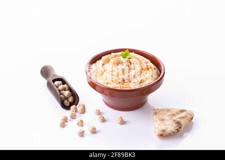 Schüssel mit hausgemachtem Hummus isoliert auf weißem Hintergrund mit Copyspace. Stockfoto