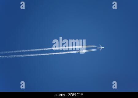 Flugzeug mit Kondensstreifen am klaren blauen Himmel, Höhe über dem Meeresspiegel. Jets verlassen weiße Spuren, oder Kondensstreifen, in ihrem Wake aus dem gleichen Grund, den Sie können someti Stockfoto