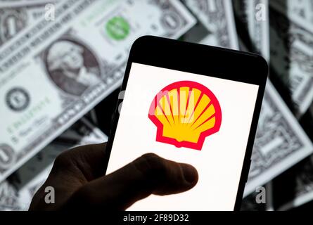 In diesem Foto Illustration, die globale Gruppe von Energie-und Petrochemie-Unternehmen Shell-Logo auf einem Android-Handy-Bildschirm mit der Währung des US-Dollar-Symbol gesehen, Dollar-Symbol im Hintergrund. Stockfoto