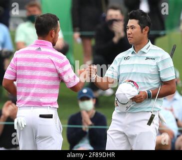 Augusta, USA. April 2021. Hideki Matsuyama, rechts, und Xander Schauffele geben sich beim Abschluss der dritten Masters-Runde am Samstag, dem 10. April 2021, in Augusta, Georgia, einen Fauststoß auf das 18. Green. (Foto von Curtis Compton/Atlanta Journal-Constitution/TNS/Sipa USA) Quelle: SIPA USA/Alamy Live News Stockfoto