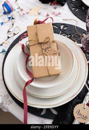 Weihnachts-Geschenkbox mit goldenem Band in einem eleganten Set aus drei Geschirr gebunden. Der Name Sean steht auf dem Tag. Stockfoto