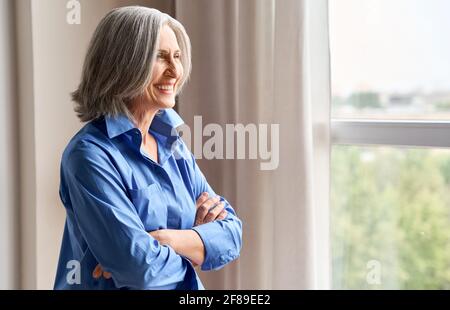 Ältere Frau mittleren Alters lächelt und genießt Wohlbefinden und Zukunftsvision. Stockfoto