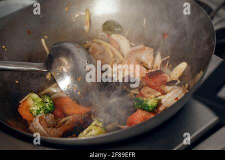 Dampfendes gemischtes Gemüse im Wok, asiatische Küche vegetarisch und gesund, ausgewählter Fokus Stockfoto