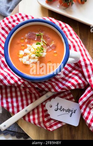 Nahaufnahme einer Schüssel mit Salmorejo, einer kalten, köstlichen spanischen Tomatensuppe, die mit einem Schriftzug mit dem spanischen Namen versehen ist. Stockfoto