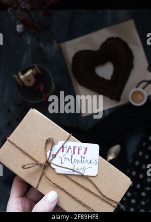 Geschenkbox mit Schriftzug, die von einer Frau am Valentinstag gehalten wird. Stockfoto