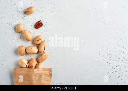 Nüsse pecan in Papiertüte auf weißem Hintergrund mit Kopierplatz. Snack vegane zuckerfreie Lebensmittel. Stockfoto