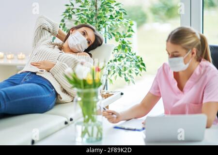 Professionelle Psychiater Beratung ihrer Patienten und Notizen sowohl in Masken Stockfoto