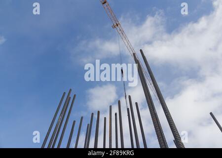 Turmkonstruktion Kran und Verstärkungen Stahlstangen gegen den blauen Himmel. Großer gelber Baukran. Armatur aus Stahlkonstruktion aus nächster Nähe. Stockfoto