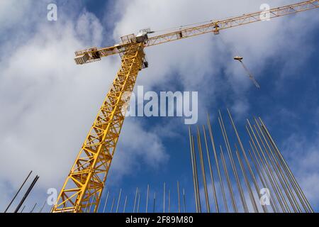 Turmkonstruktion Kran und Verstärkungen Stahlstangen gegen den blauen Himmel. Großer gelber Baukran. Armatur aus Stahlkonstruktion aus nächster Nähe. Stockfoto