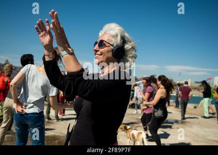 Barcelona, Spanien. April 2021. Am 21. März 2021 tanzt eine Frau bei einer stillen Disco-Strandveranstaltung am Strand von Barceloneta in Barcelona, Spanien. Sonnige Tage und lockere Einschränkungen veranlassten Menschen, nach draußen zu kommen und kleine Veranstaltungen zu organisieren (Foto von Davide Bonaldo/Sipa USA)(Foto von Davide Bonaldo/Sipa USA) Quelle: SIPA USA/Alamy Live News Stockfoto