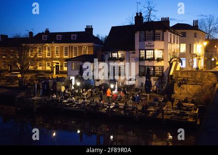 Henley-on-Thames, Großbritannien, 12. April 2021: Im Angel Pub bietet eine Terrasse am Fluss einen beliebten Ort, um die zweite Stufe der Lockerung zu feiern, indem man mit Freunden im Freien isst und trinkt. Anna Watson/Alamy Live News Stockfoto