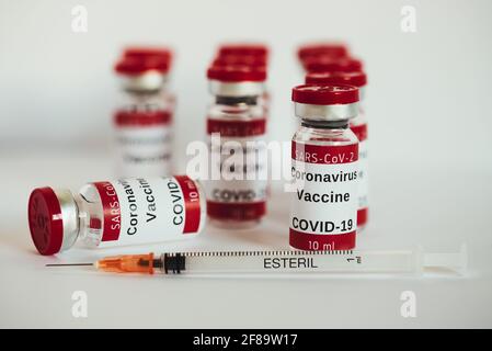 Covid-19-Impfstoff – Impfflaschen für Coronaviren. Injektionsfläschchen und Spritze auf weißem Hintergrund. Die Spritze ist neben einem Fläschchen, das sich hinlegt, leer. Stockfoto