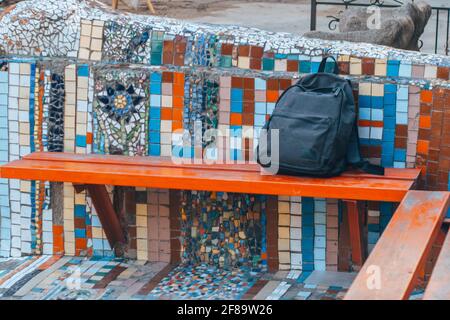 Ein verloren gegangener Rucksack, der auf einer Parkbank liegt. Stockfoto