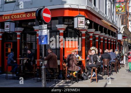 12. April 2021. Soho, London. Gäste im Coach and Horses Pub, nachdem die britische Regierung die Einschränkungen der Covid-Regierung in England lockerte, die es erlauben, Speisen und Getränke an Tischen im Freien zu servieren. Stockfoto