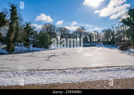 Kleiner gefrorener See, der mit Schnee bedeckt ist, hinter der Kunstgalerie bremen in der Sonne Stockfoto