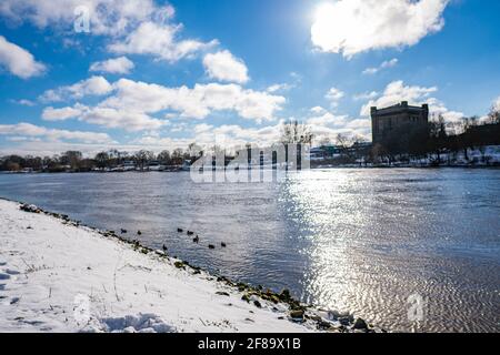 Schöne weser und verschneiten Deich mit Wasserturm in Der Hintergrund an einem warmen sonnigen Wintertag in bremen Stockfoto