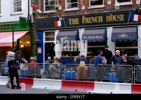 12. April 2021. Soho, London. Kunden im French House Pub, nachdem die britische Regierung die Covid-Beschränkungen in England lockerte, die das Servieren von Speisen und Getränken an Tischen im Freien erlauben. Stockfoto