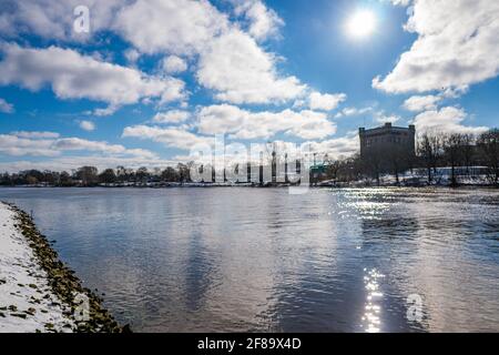 Schöne weser und verschneiten Deich mit Wasserturm in Der Hintergrund an einem warmen sonnigen Wintertag in bremen Stockfoto