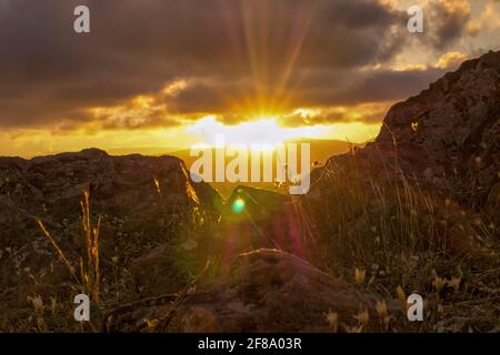 Sonnenuntergang vom Ceferino-Hügel, Sierra de la Ventana. Aufgenommen vom felsigen Boden mit Blick auf die Sonne Stockfoto