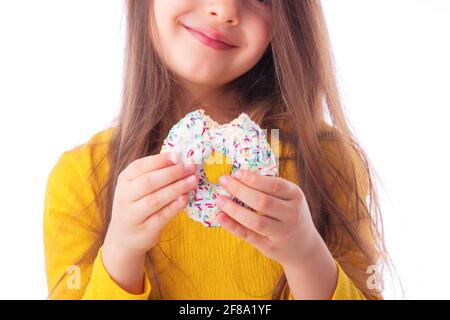 Süßes kleines Mädchen, das weißen Donut isst Stockfoto