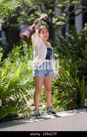 Asiatischer Teenager, der mit Ukulele steht Stockfoto