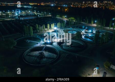 Moderne Kläranlage, Luftaufnahme bei Nacht. Tanks zur Belüftung und Reinigung von Abwasser. Stockfoto