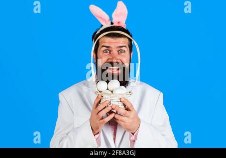 Lächelnder bärtiger Mann in Anzug mit Körbcheneiern. Vorbereitung auf Ostern. Eiersuche. Osterferien. Stockfoto