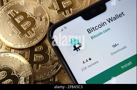Bitcoin Wallet App auf dem Smartphone-Bildschirm auf dem oberen Bitcoin-Münzstapel platziert gesehen. Konzept. Stafford, Großbritannien, 12. April 2021. Stockfoto