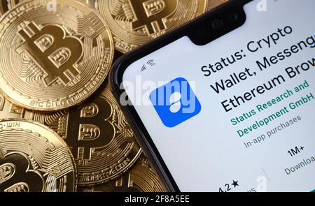 Status Crypto Wallet App auf dem Smartphone-Bildschirm auf dem oberen Bitcoin-Münzstapel platziert gesehen. Konzept. Stafford, Großbritannien, 12. April 2021. Stockfoto